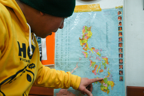 Ruel Neri pointing at his hometown on a map of the Philippines